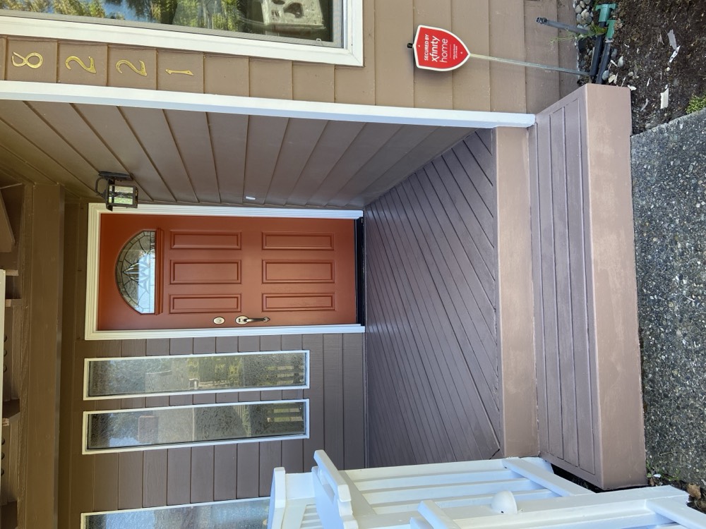 The same porch with freshly stained decking and a terracotta door
