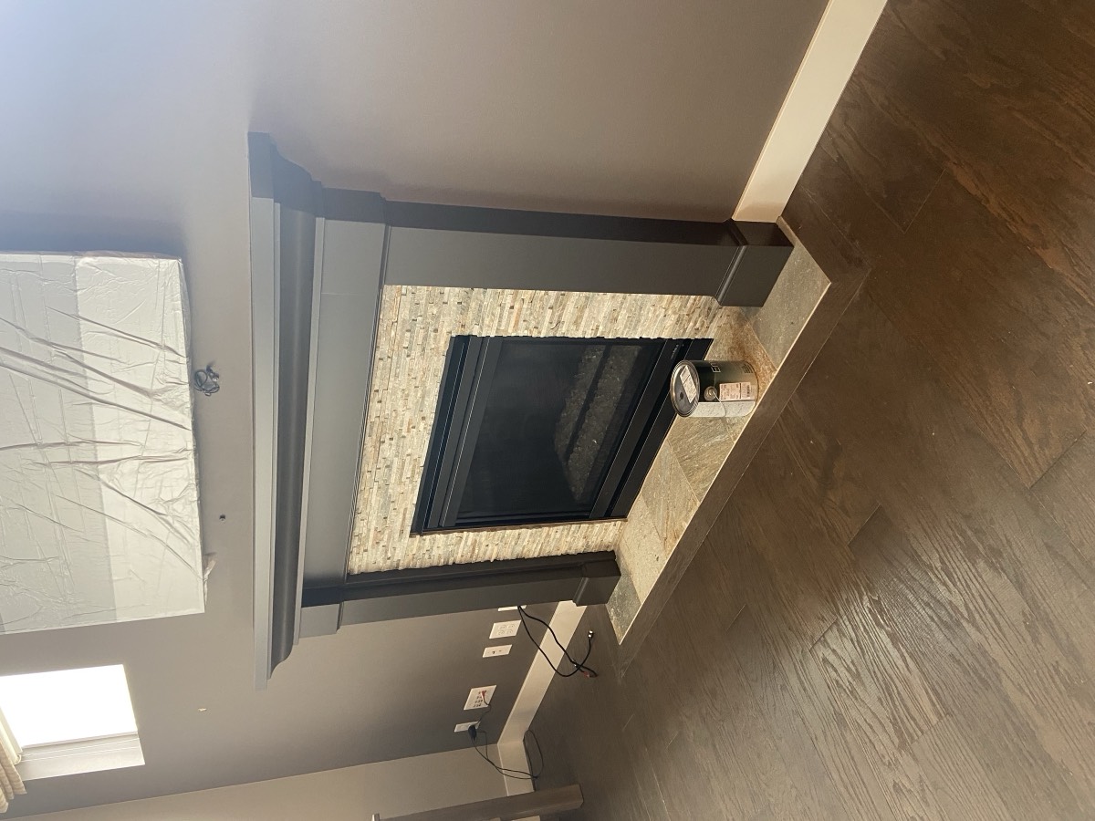 Fireplace mantel and surround finished in charcoal gray