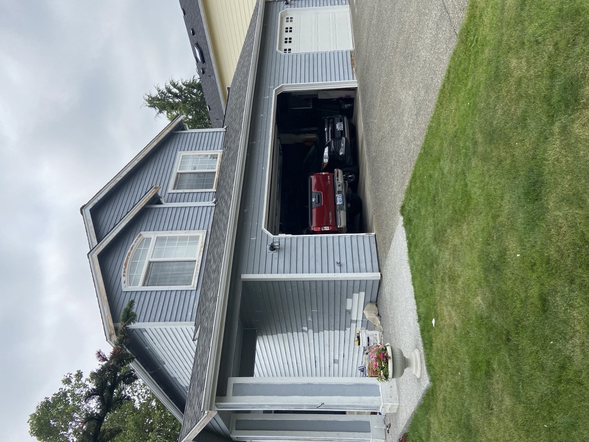 Two-story home repainted in blue-gray with fresh landscaping